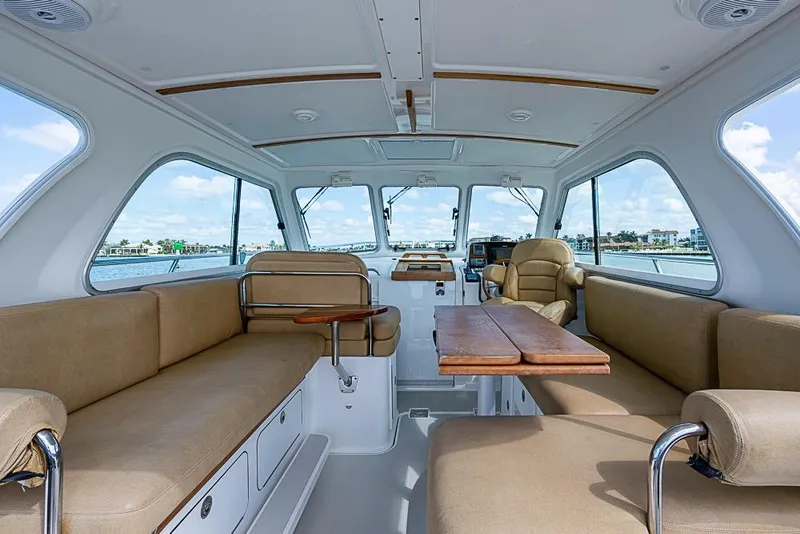 Slide: The Image of Interior of 2011 Back Cove 30 boat with beige seating and wooden table. - 8