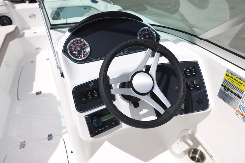 Slide: The Image of 2026 Hurricane SunDeck 2400 OB boat dashboard with steering wheel and control panel. - 16