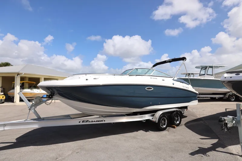 Slide: The Image of 2026 Hurricane SunDeck 2400 OB boat on trailer under blue sky. - 27