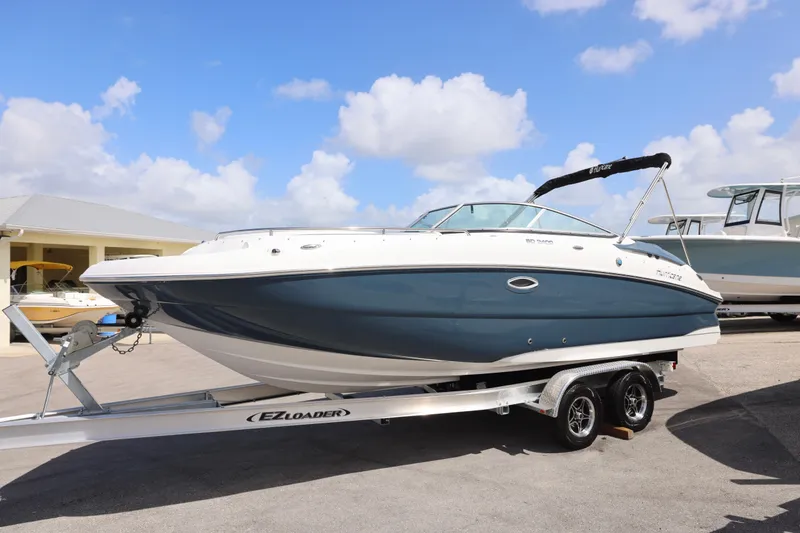 Slide: The Image of 2026 Hurricane SunDeck 2400 OB boat on trailer under blue sky. - 28