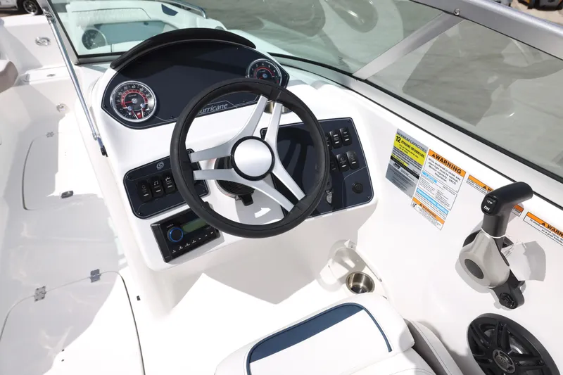 Slide: The Image of 2026 Hurricane SunDeck 2400 OB boat dashboard with steering wheel and control panel. - 4