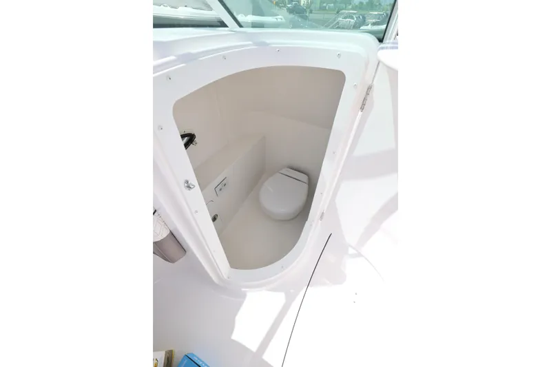 Slide: The Image of 2026 Hurricane SunDeck 2400 OB boat interior with compact marine toilet. - 6