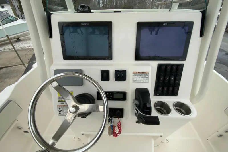 Slide: The Image of 2019 Century 2301 Center Console boat dashboard with steering wheel and navigation screens. - 12