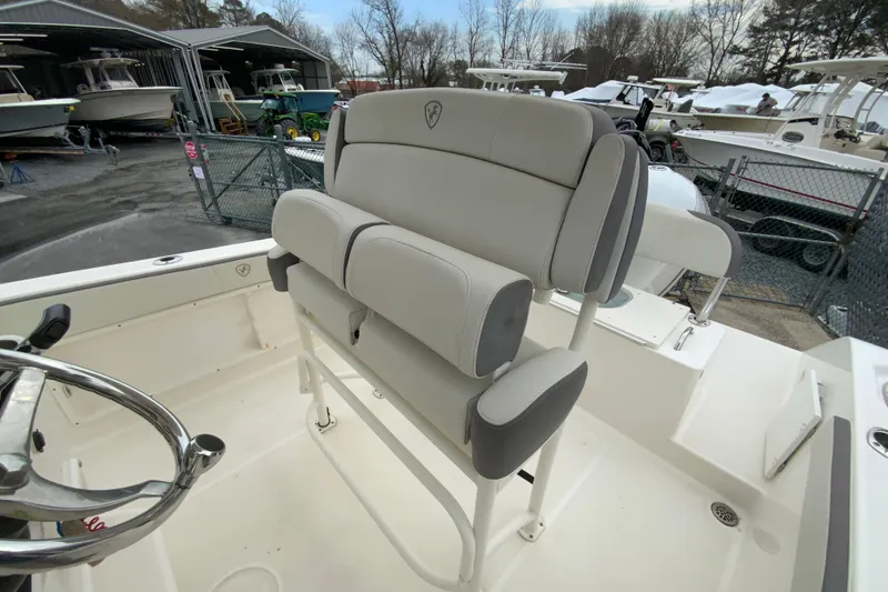 Slide: The Image of 2019 Century 2301 Center Console boat with cushioned seating and steering wheel, docked outdoors. - 14
