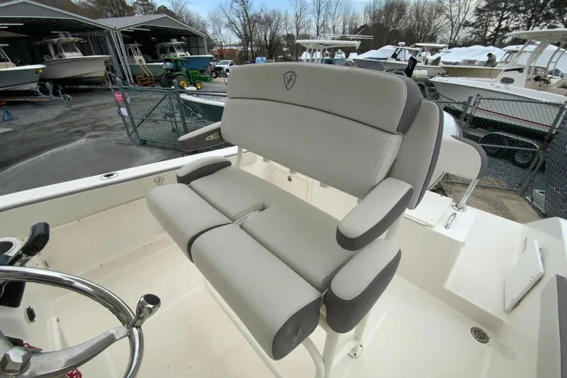 Slide: The Image of 2019 Century 2301 Center Console boat with cushioned seating in a marina setting. - 15