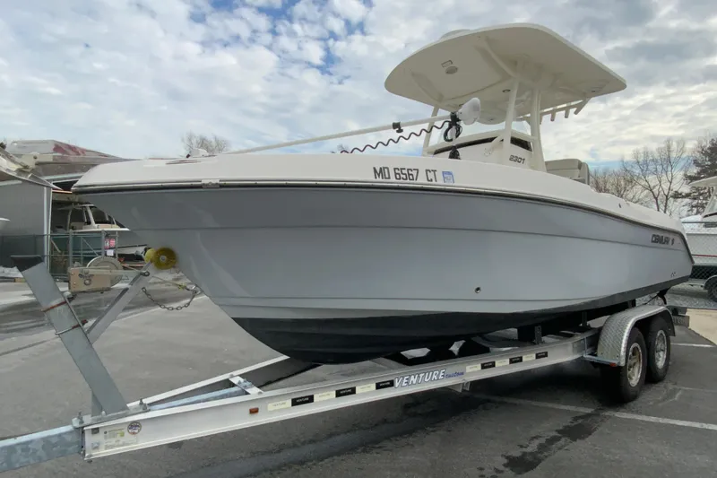Slide: The Image of 2019 Century 2301 Center Console boat on trailer, parked outdoors under cloudy sky. - 5