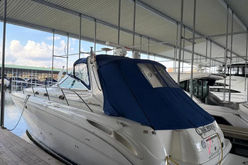 The Image of 2000 Sea Ray 380 Sundancer yacht docked under a covered marina. - 0
