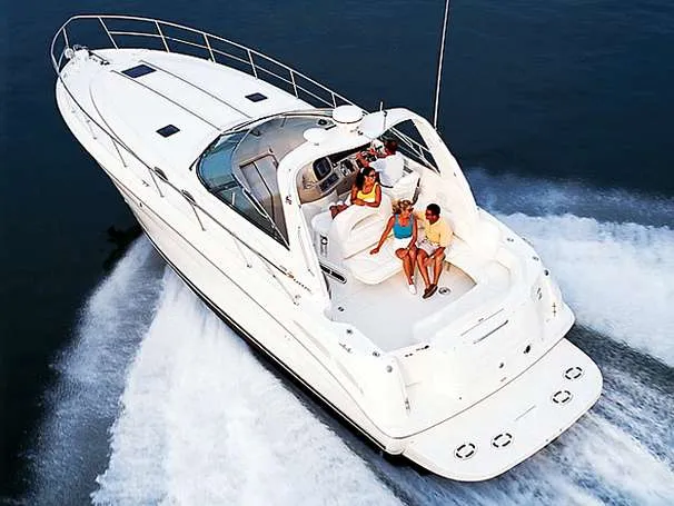 Slide: The Image of 2000 Sea Ray 380 Sundancer cruising with passengers on deck, creating a wake in the water. - 13