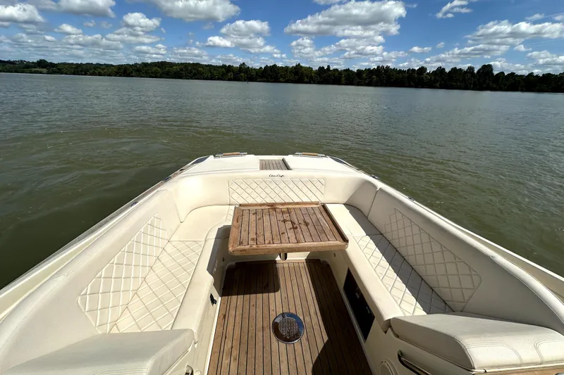Slide: The Image of 2019 Chris-Craft Launch 30 boat interior with elegant seating and wooden table on a lake. - 12