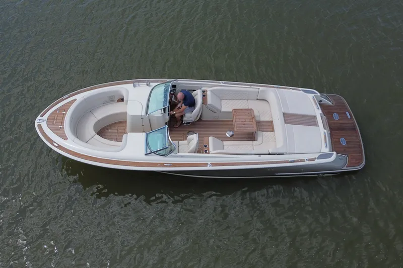 Slide: The Image of 2019 Chris-Craft Launch 30 boat on water, featuring elegant design and spacious seating. - 16