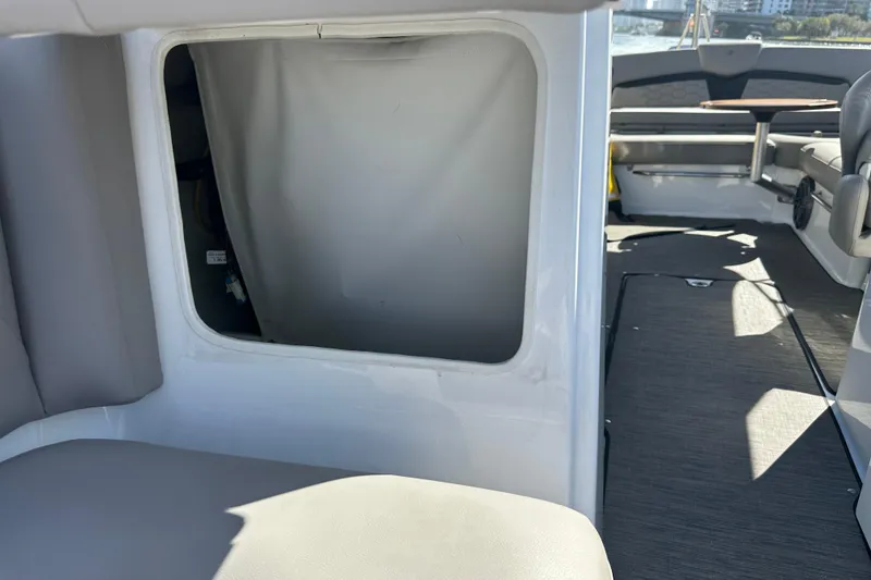 Slide: The Image of 2022 Four Winns HD8 OB boat interior with open storage compartment and seating area. - 16