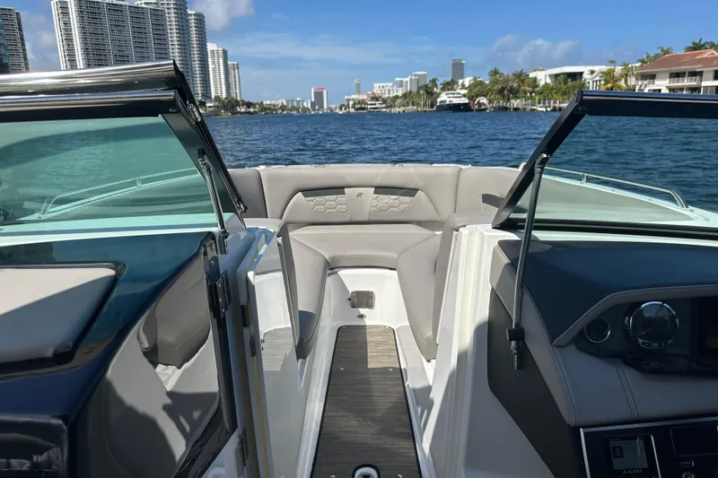 Slide: The Image of Interior view of 2022 Four Winns HD8 OB boat with waterfront cityscape background. - 22