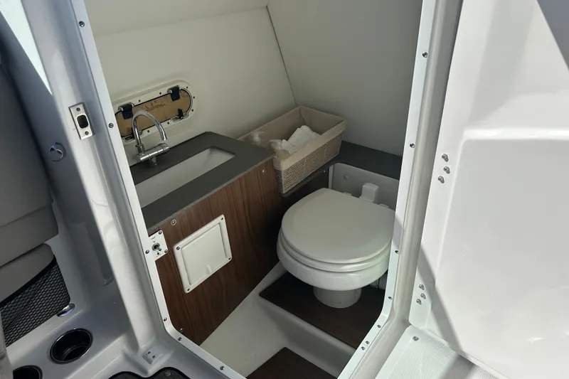 Slide: The Image of 2022 Four Winns HD8 OB boat bathroom with sink, toilet, and storage basket. - 26