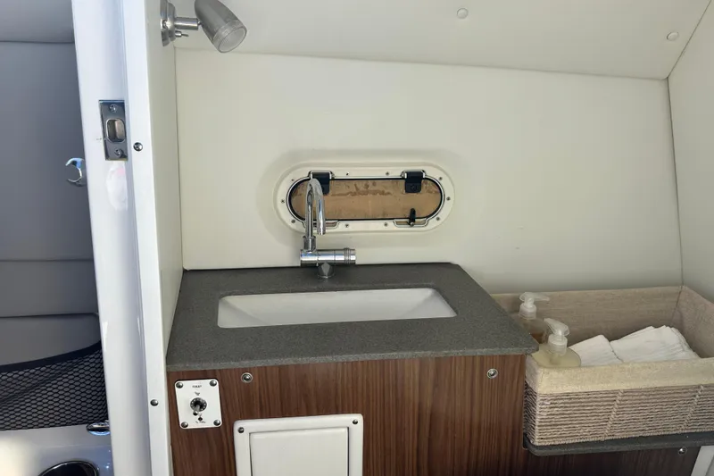 Slide: The Image of 2022 Four Winns HD8 OB boat interior with sink, faucet, and storage basket. - 27