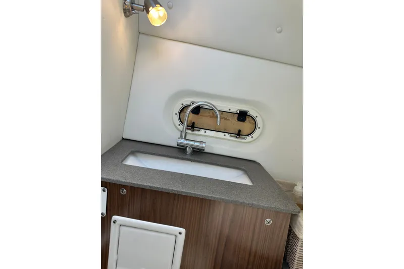 Slide: The Image of 2022 Four Winns HD8 OB boat interior with sink and porthole window. - 28