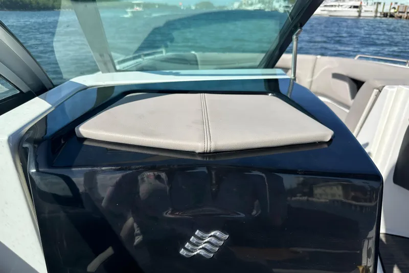 Slide: The Image of 2022 Four Winns HD8 OB boat interior with cushioned seating and windshield, on a sunny day. - 29