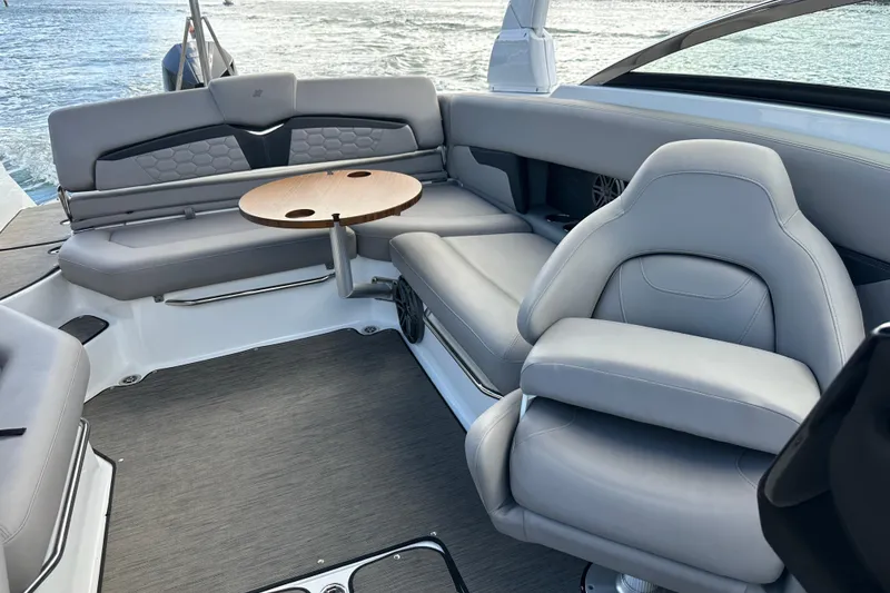 Slide: The Image of 2022 Four Winns HD8 OB boat interior with gray seating and round table. - 36