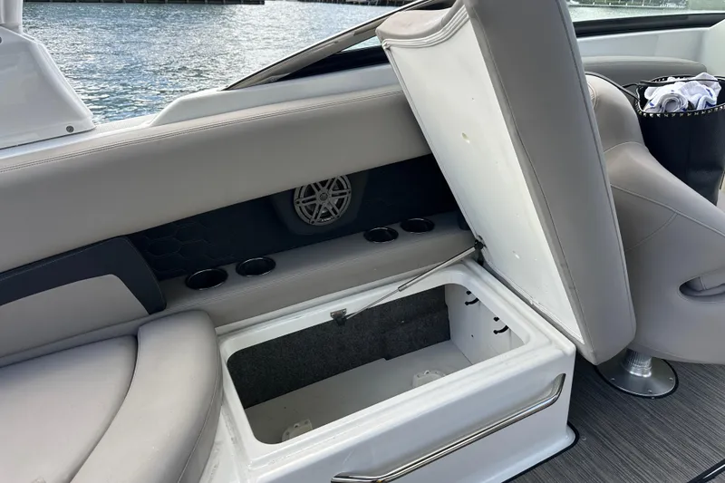 Slide: The Image of 2022 Four Winns HD8 OB boat interior with open storage compartment and cup holders. - 38