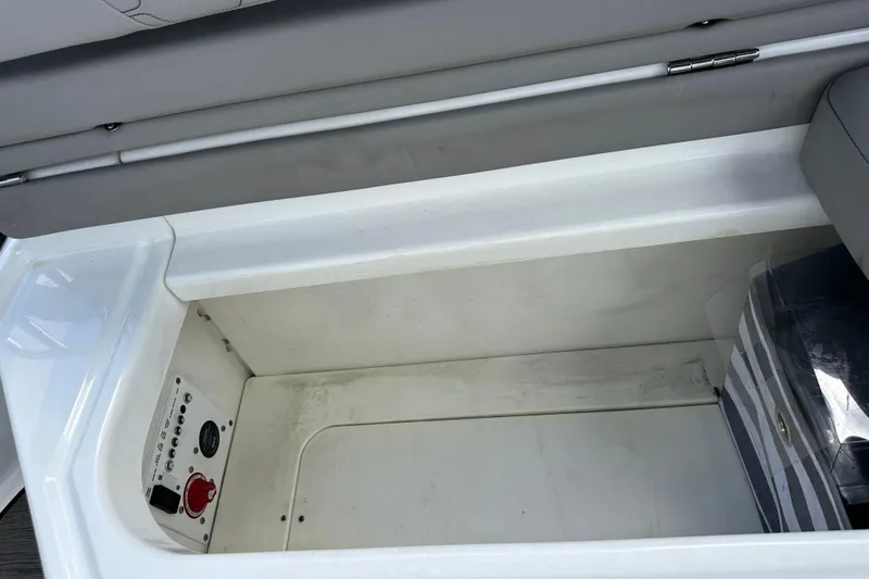 Slide: The Image of Storage compartment in 2022 Four Winns HD8 OB boat, featuring control panel and striped bag. - 42