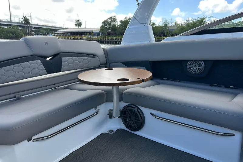 Slide: The Image of 2022 Four Winns HD8 OB boat interior with gray seating and wooden table. - 46