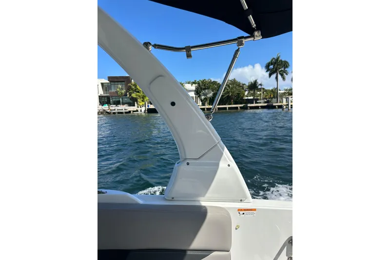 Slide: The Image of 2022 Four Winns HD8 OB boat on water, featuring sleek design and sunny waterfront view. - 50