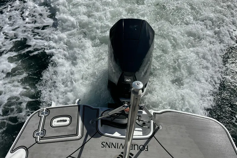 Slide: The Image of 2022 Four Winns HD8 OB boat with outboard motor on water, creating a wake. - 57