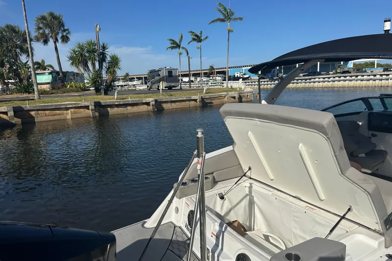Slide: The Image of 2022 Four Winns HD8 OB boat docked by a scenic waterfront with palm trees. - 65
