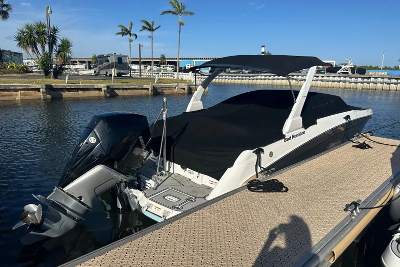 Slide: The Image of 2022 Four Winns HD8 OB boat docked with black cover and outboard motor. - 66