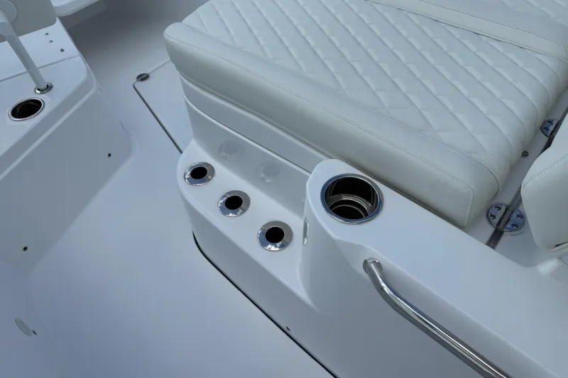 Slide: The Image of 2026 Everglades 315 Center Console boat interior with white seating and cup holders. - 10