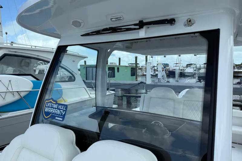 Slide: The Image of 2026 Everglades 315 Center Console boat with lifetime hull warranty sticker at marina. - 13