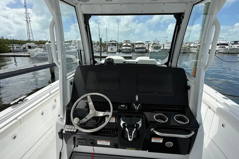 Slide: The Image of 2026 Everglades 315 Center Console boat dashboard with steering wheel and controls. - 15
