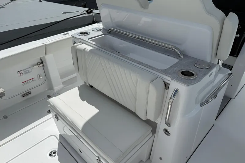 Slide: The Image of 2026 Everglades 315 Center Console boat interior with cushioned seating and storage. - 23