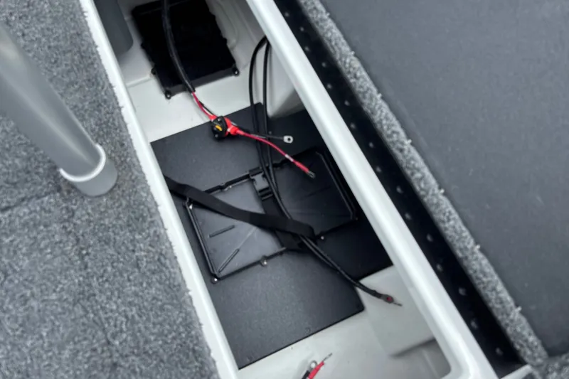 Slide: The Image of Open storage compartment in 2026 Nitro Z17 boat, featuring wiring and battery setup. - 25