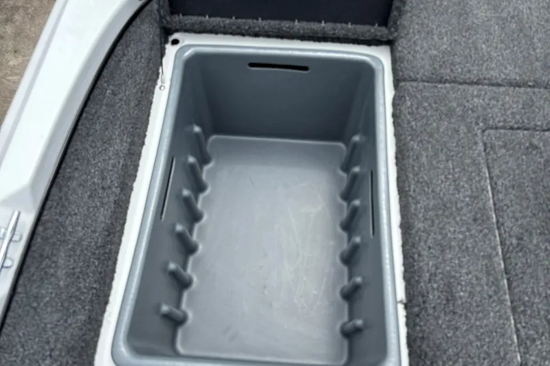 Slide: The Image of Storage compartment in a 2026 Nitro Z17 boat, featuring a gray interior and carpeted edges. - 23