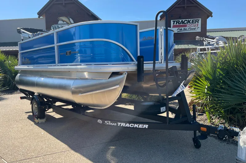The Image of 2026 Sun Tracker Party Barge 16 DLX pontoon boat on trailer, displayed outdoors. - 0