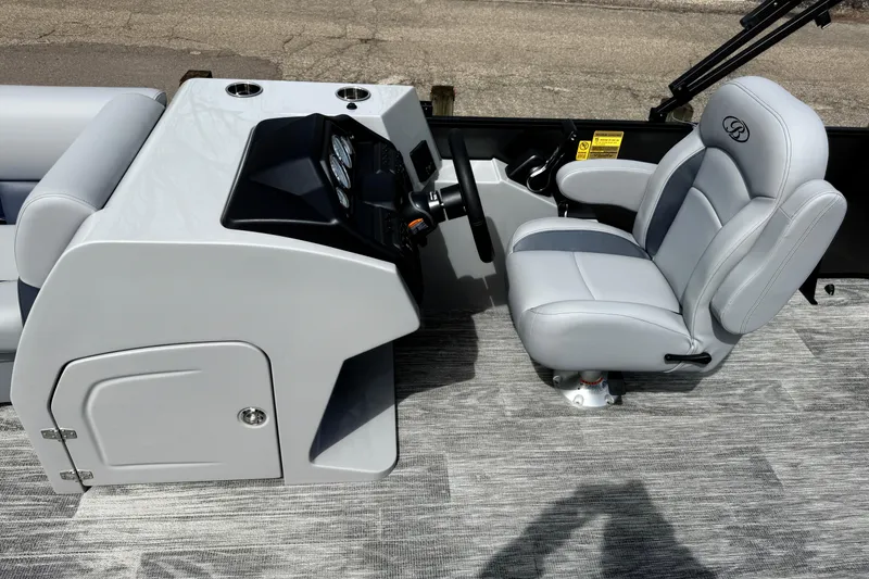 Slide: The Image of 2026 Bentley Pontoons Legacy 220 Cruise XL helm with sleek gray captain's chair and console. - 13