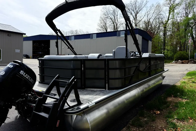 Slide: The Image of 2026 Bentley Pontoons Legacy 220 Cruise XL with Suzuki engine, parked outdoors near industrial buildings. - 4