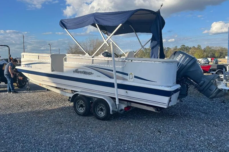 The Image of 2005 Hurricane FunDeck 226 boat with Yamaha outboard motor on a trailer. - 1