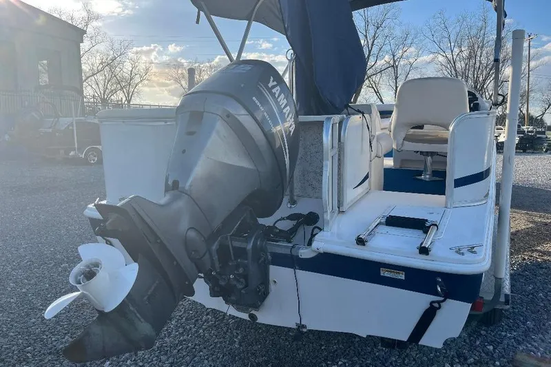 Slide: The Image of 2005 Hurricane FunDeck 226 boat with Yamaha outboard motor, parked on gravel. - 7