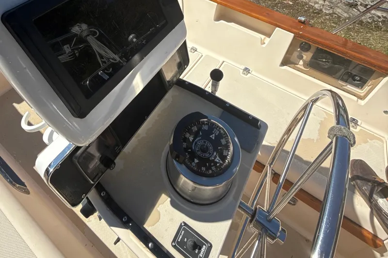 Slide: The Image of 1995 Island Packet 37 sailboat cockpit with steering wheel and navigation equipment. - 13