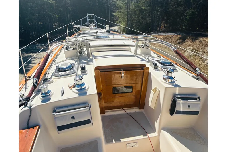 Slide: The Image of 1995 Island Packet 37 sailboat cockpit with steering wheel and seating area. - 16