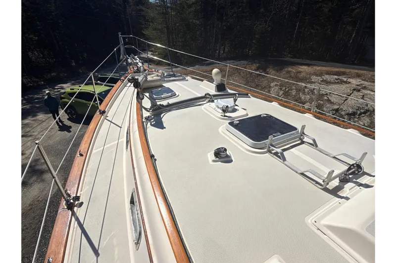 Slide: The Image of 1995 Island Packet 37 sailboat deck with wooded shoreline in background. - 18