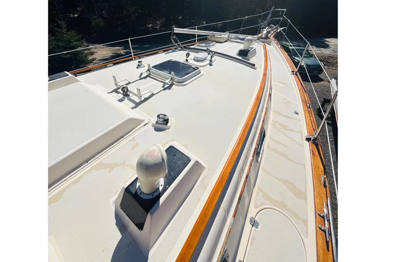 Slide: The Image of 1995 Island Packet 37 sailboat deck with wooded surroundings and clear sky. - 19