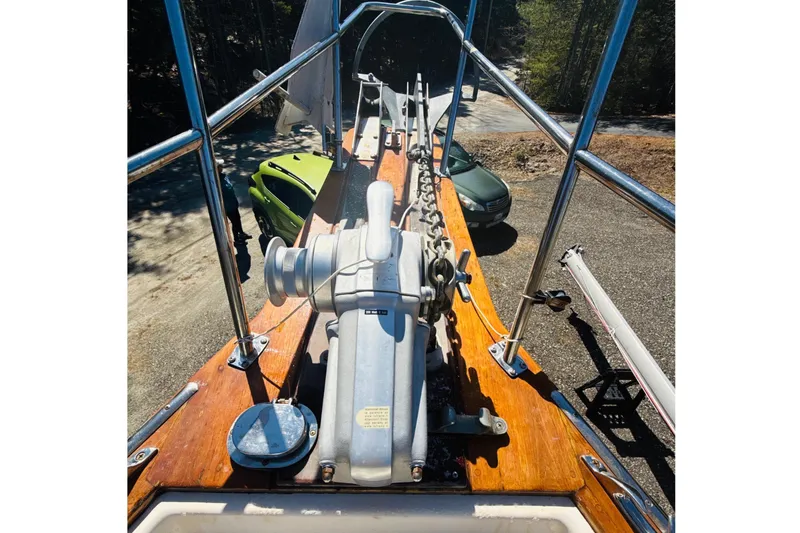 Slide: The Image of 1995 Island Packet 37 sailboat deck with wooden trim, surrounded by trees. - 21