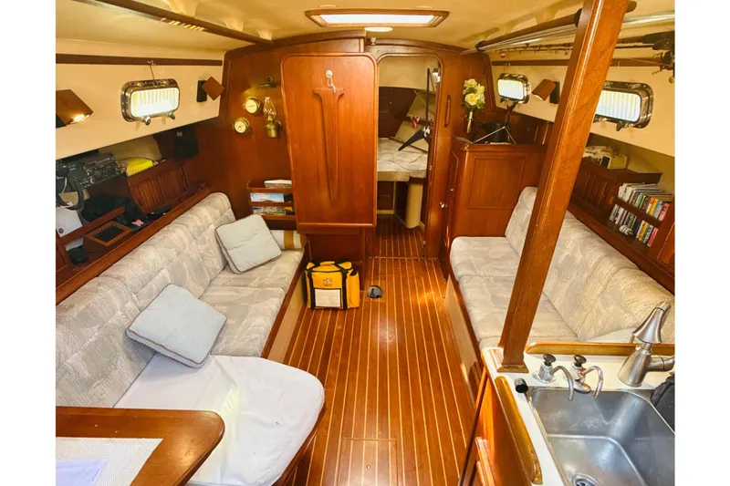 Slide: The Image of 1995 Island Packet 37 sailboat deck with open hatch, surrounded by trees. - 25