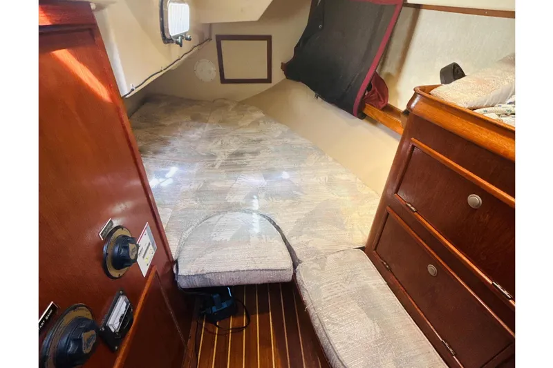 Slide: The Image of Interior of a 1995 Island Packet 37 sailboat, featuring cozy seating and wooden finishes. - 27