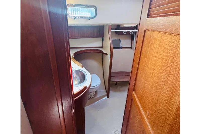 Slide: The Image of Interior of 1995 Island Packet 37 sailboat with wooden cabinetry and floral decor. - 43