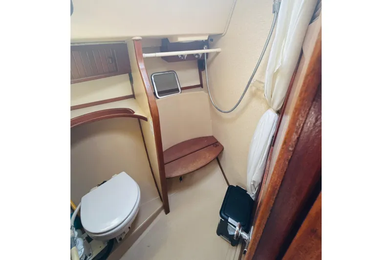 Slide: The Image of Interior view of 1995 Island Packet 37 sailboat bathroom with wooden cabinetry and skylight. - 45