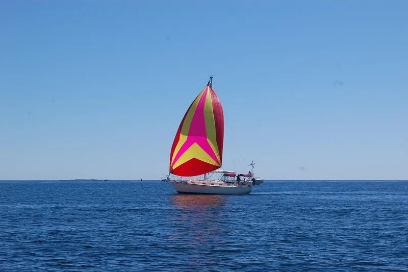 Slide: The Image of Sailboat Island Packet 37 (1995) with colorful spinnaker on open sea. - 60