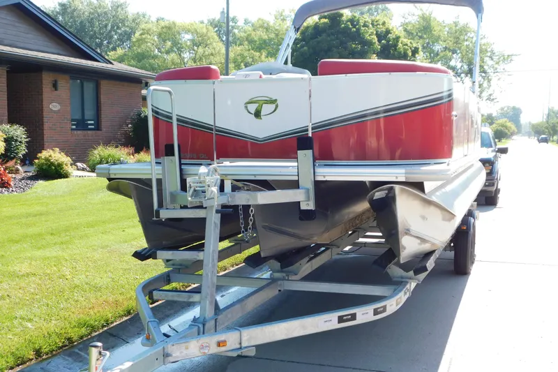 Slide: The Image of 2023 Tahoe Pontoon 2385 LTZ Quad Lounger on trailer, parked in residential area. - 2